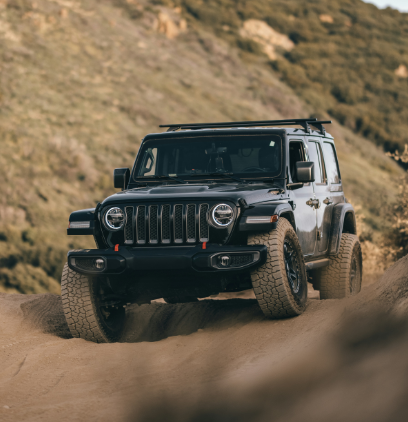 A black Jeep driving on a dirt mountain road